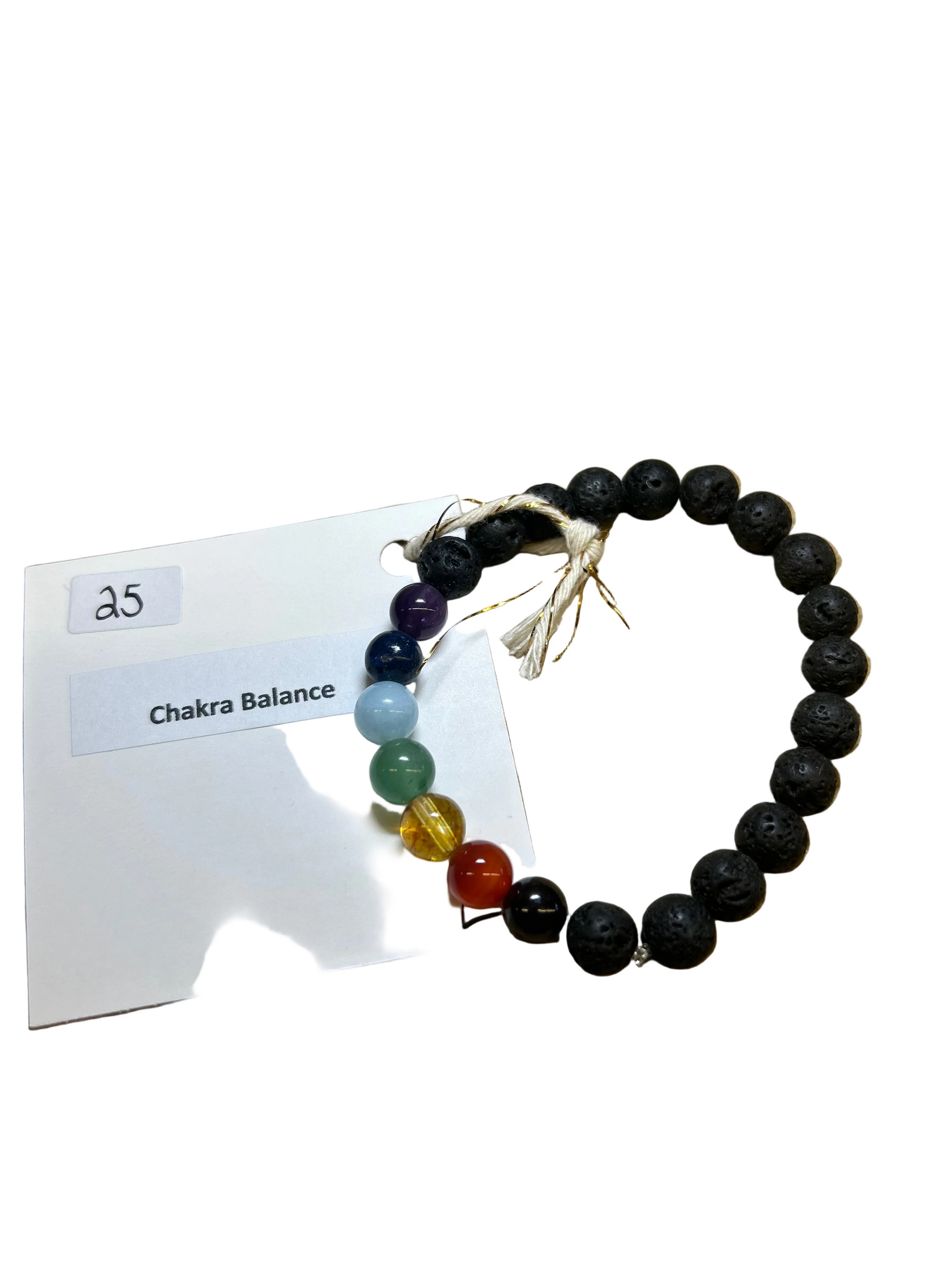Black beaded bracelet with colored beads on a wooden surface, accompanied by a card labeled 'Chakra Balance'.